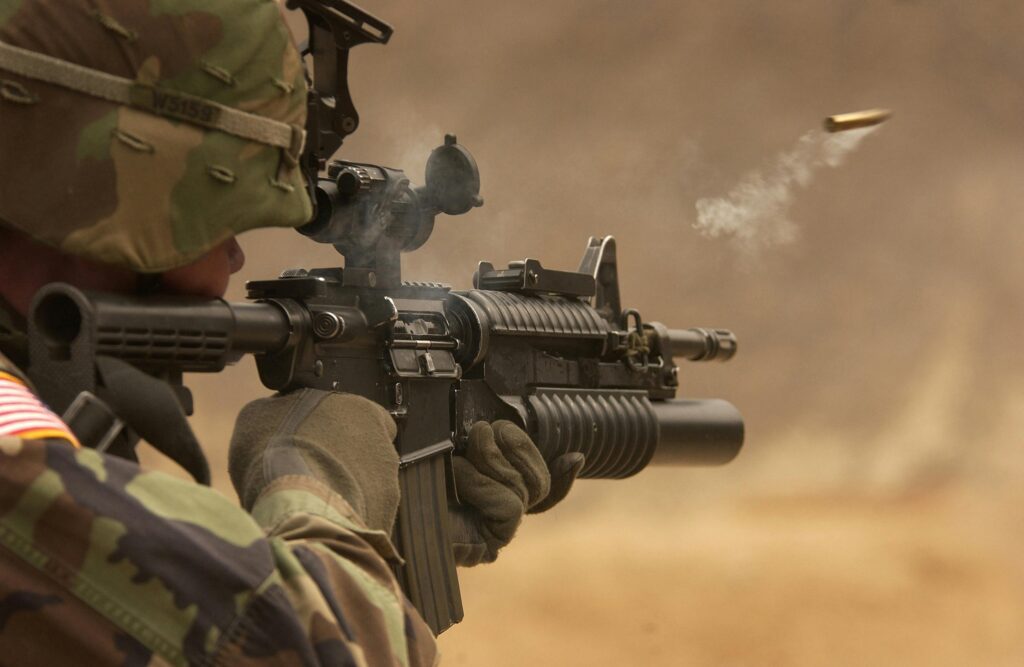 Close-up of a soldier in camo firing a rifle in action during training.